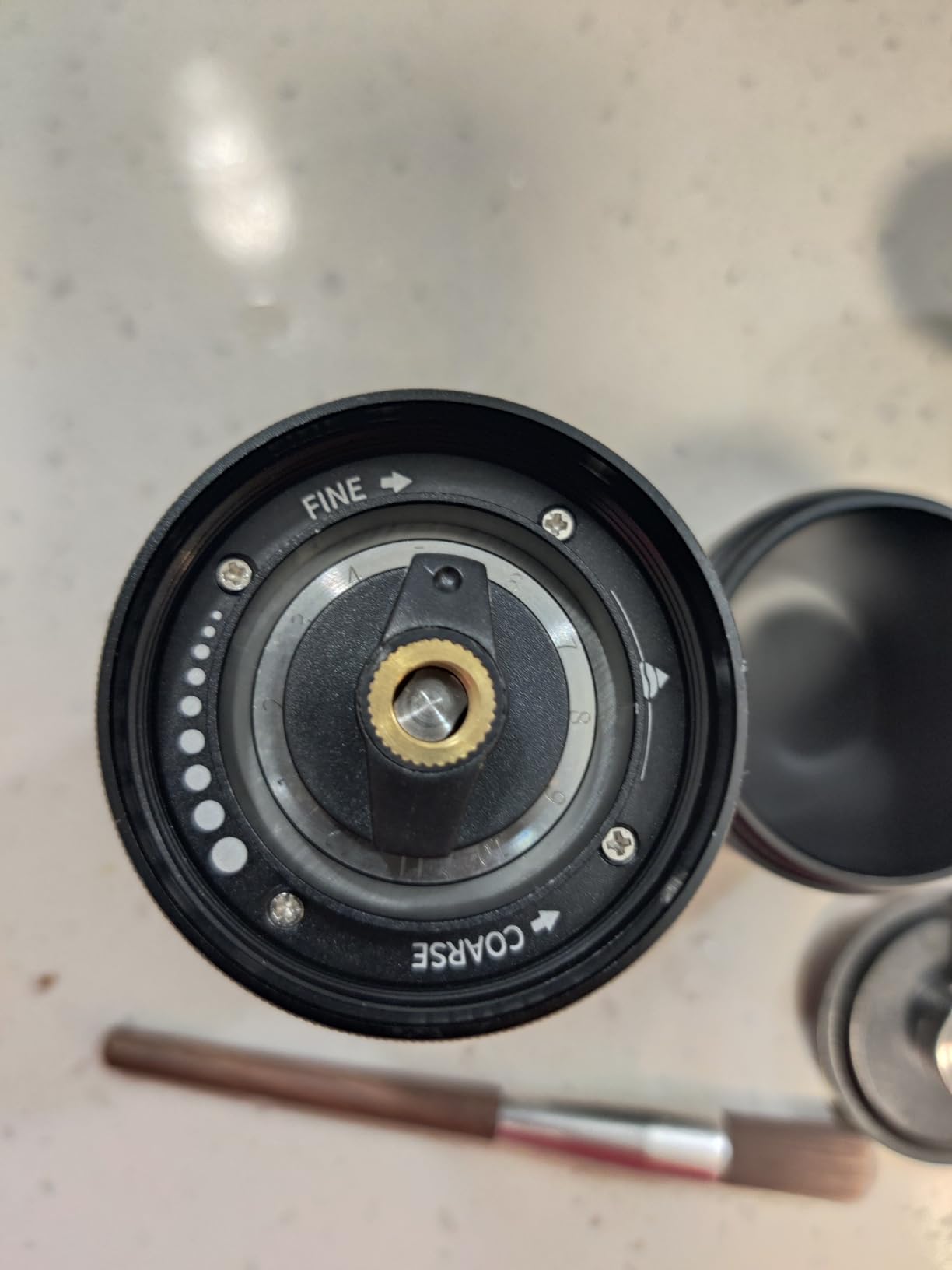 Close-up of the Alpaca adjustment dial marked FINE and COARSE under the burr